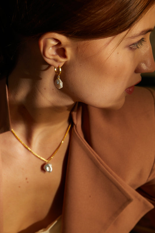 the subtle affirmation golden hoop pearl earrings