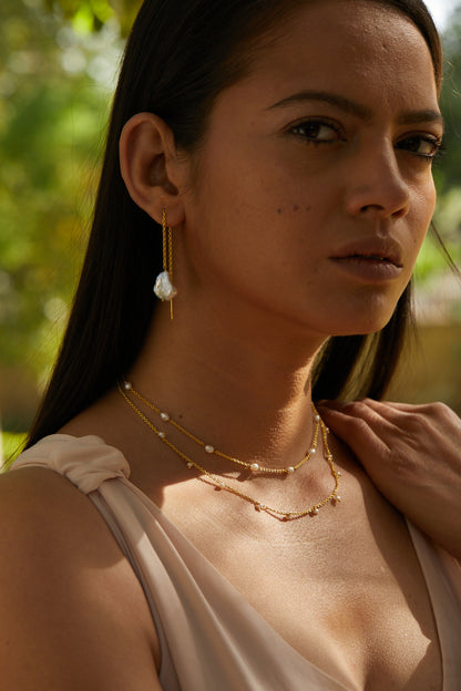 a divine allure golden pearl earrings.